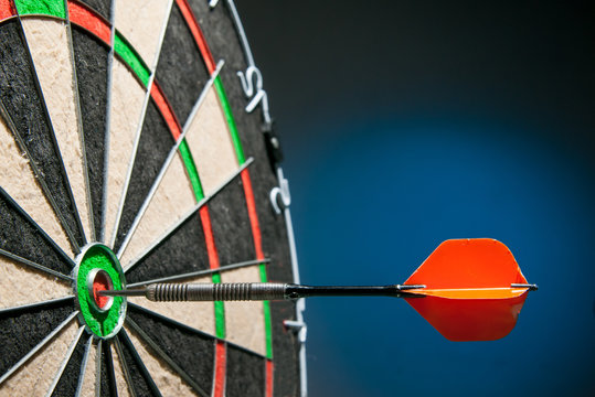 Close-up view of a red dart on the bullseye of a dartboard - Powered by Adobe