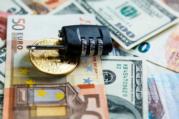 lock on  bitcoins on real money background. Internet  security, risk, investment, business concept