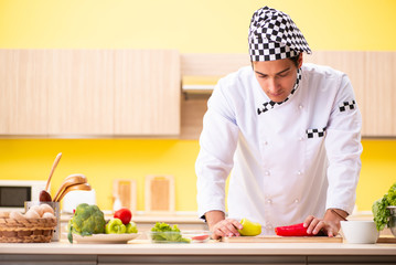 Young professional cook preparing salad at home
