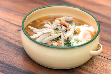 Close up of Vietnamese rice noodle soup with sliced ​​pork and chicken feet spicy soup in bowl with sauce on wooden table , Traditional food of Vietnamese.