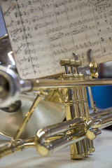 Obraz premium Detail of a trombone's pistons and music sheet in the background