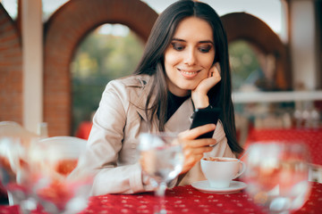Woman Checking Her Smartphone in a Restaurant