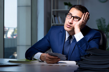 Young business playing cards late in office