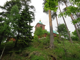 Fototapeta na wymiar Church on the background of mountainous terrain and pine trees on the island of Valaam.