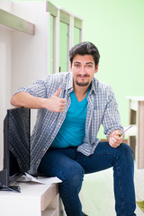 Young man husband repairing tv at home 