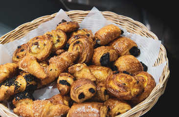 French croissants on wicker basket, bakery background