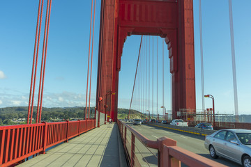 bright red column of Golden Gate Bridge against blue sky.