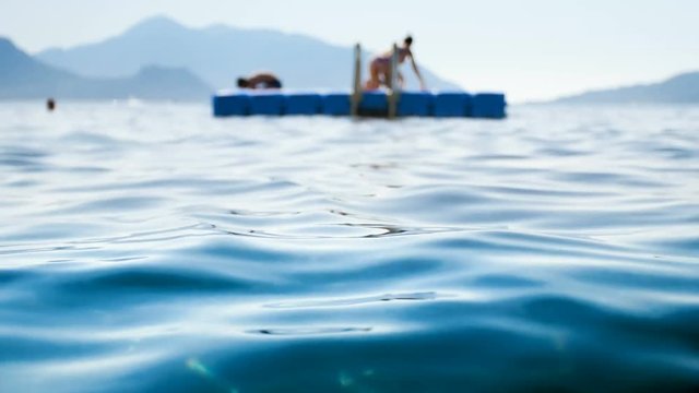 4k out of focus video of happy people relaxing on floating plastic pontoon at the sea