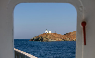 View from ship's door of lighthouse and agios Nikolaos church. Kea,Tzia island, Greece. Sky background.