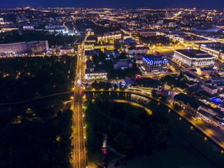 Fototapeta na wymiar Panoramic aerial view of illuminated street and city buildings at night. Minsk, Belarus