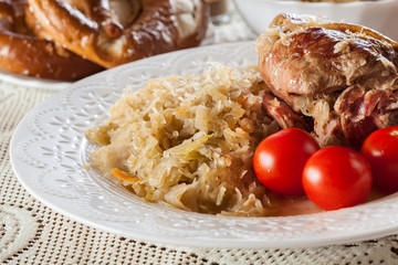 Pork knuckle with fried sauerkraut and tomatoes