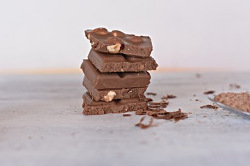 Pile of chocolate blocks and hazelnut isolated on white background