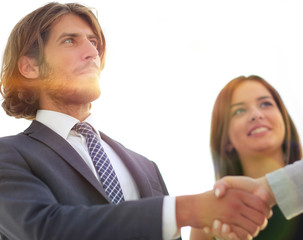 Businesspeople  shaking hands against room with large window loo