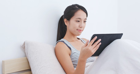 Woman use of tablet computer on bed