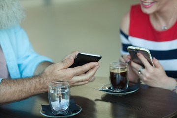 Close-up Of Two People Hands using smartphone.