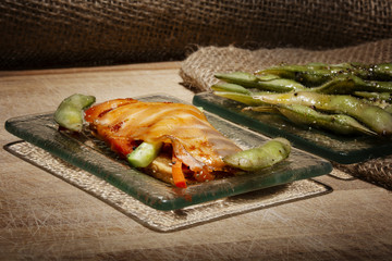 Slices of salmon on a plate with vegetables, snack for a bar