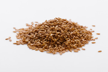 Seeds of golden flax on a white background