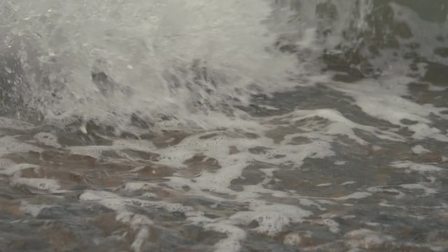 Silky waves on the sea pebbles. Shingle beach
