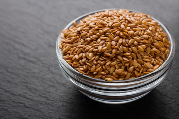 seeds of golden flax on a dark stone background