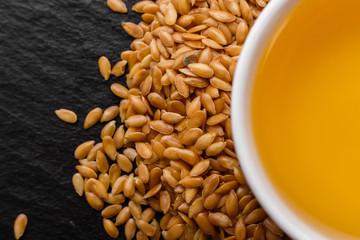 seeds of golden flax on a dark stone background