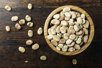 raw dry beans in a plate on a wooden background. top view.