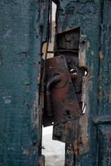 Detail of a broken door lock. Old wooden gate. Abandoned building.