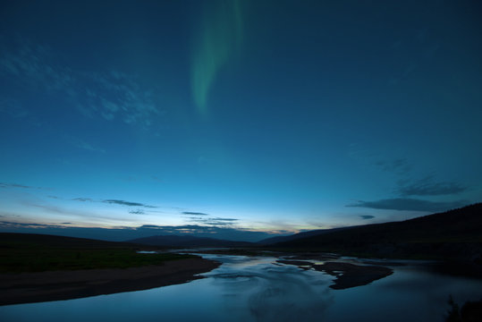 Polar light over the Langot-Egan River on the summer night. Polar Ural Mountains, Russia