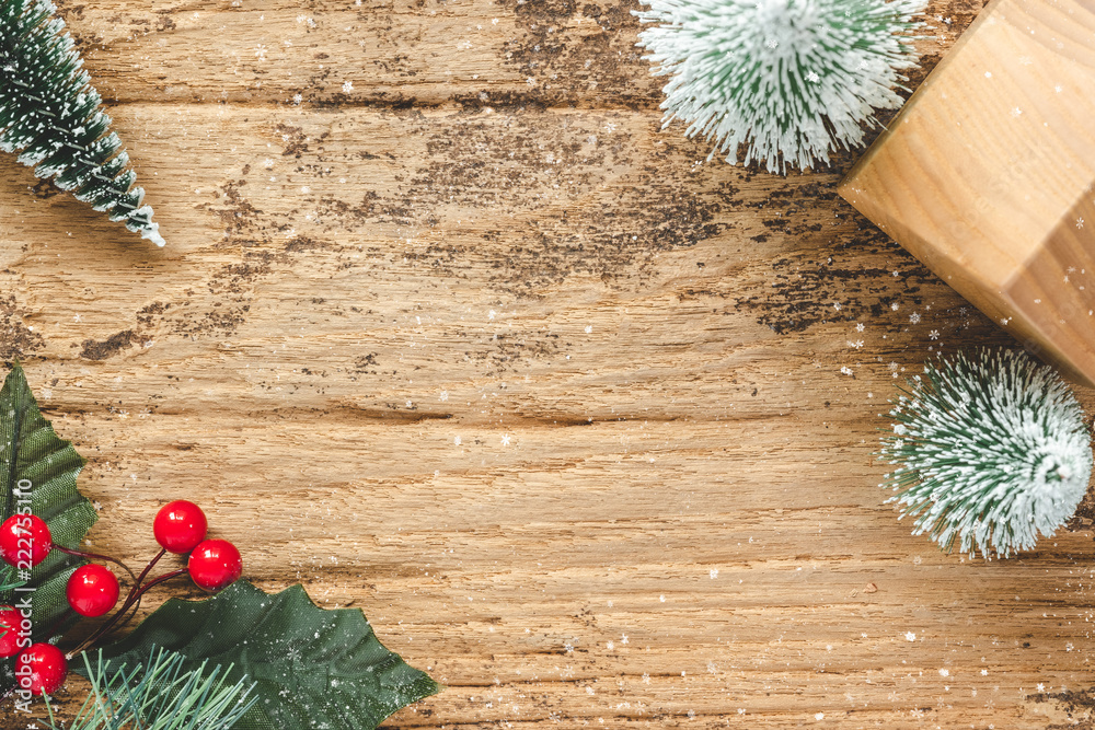 Aufkleber top view of mini christmas tree and red burry leaf with wood home toy on rustic wooden table with sn