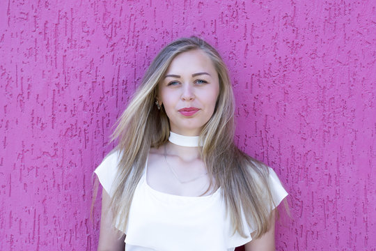 Blond Girl Standing Against Pink Wall