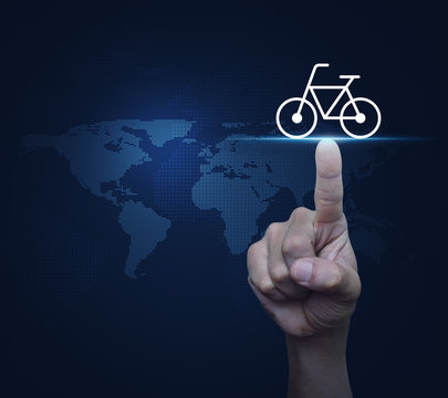 Hand pressing bicycle flat icon over digital world map, Business bicycle service online concept, Elements of this image furnished by NASA