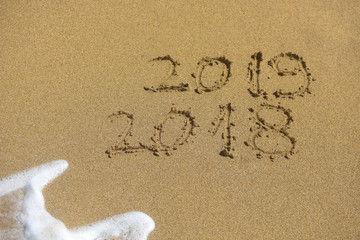 New Year 2019 concept. The inscription on the sand a number message Year 2018 replace 2019