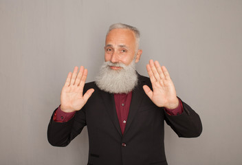 Hello! A happy middle aged bearded man shows his hand a greeting sign.