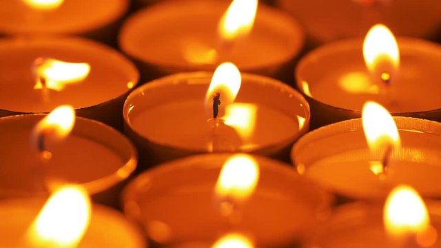 UHD shallow depth of field macro of burning candles on the rotating stand