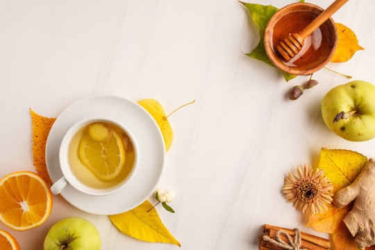 Autumn tea with ginger, lemon and fruits on a white background, copy space.