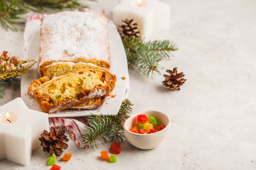 Christmas bread with candied fruits and powdered sugar in Christmas decorations.