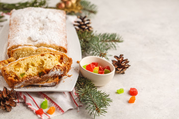 Christmas bread with candied fruits and powdered sugar in Christmas decorations.