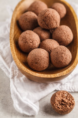 Raw vegan balls from nuts and cocoa in a wooden bowl.