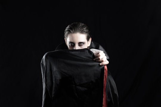 Woman in a vampire costume for halloween. Studio shot of a young female dressed up in dracula costume on black background