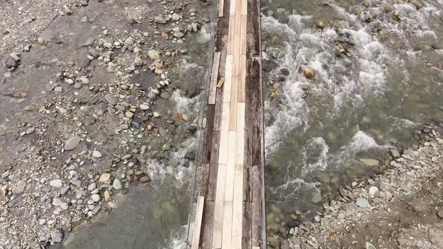 Flying over a rickety suspension footbridge crossing the Rio Cosanga on the Amazonian slopes of the Andes in Ecuador.