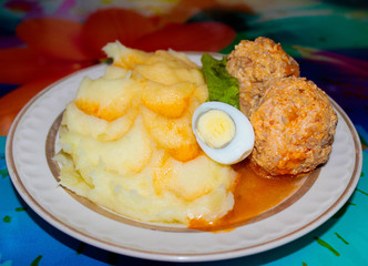 Mashed potatoes on a plate with meatballs
