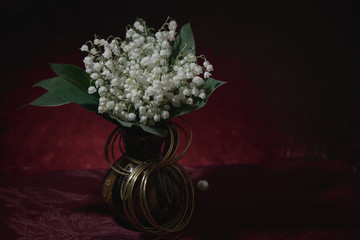 A bouquet of lilies of the valley in a vase.