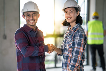 Group of officer teamwork is happy and shake hands to celebrate in success of finish in job planning about home building construction project