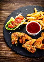 Grilled chicken wings, chips and vegetables