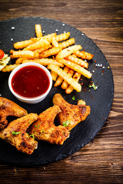 Grilled chicken wings, chips and vegetables