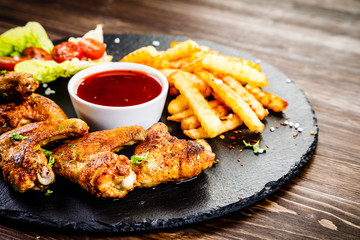 Grilled chicken wings, chips and vegetables