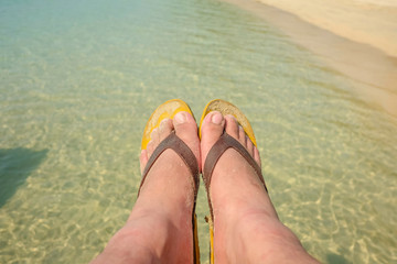 Asian guy foot wear sandal on the beach in vacation time