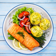 Grilled salmon with boiled potatoes, asparagus and vegetable salad