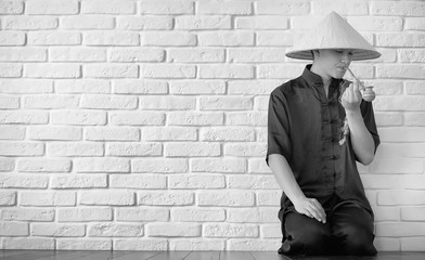 Asian novice on a white brick wall