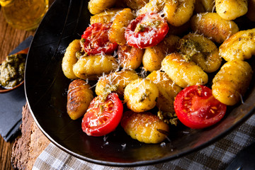 gnocchi baked with green pesto, cherry tomatoes and parmesan