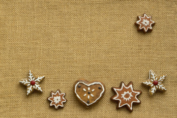 Herz und Sterne aus Lebkuchen mit Zuckerornamenten auf Hintergrund aus Jute